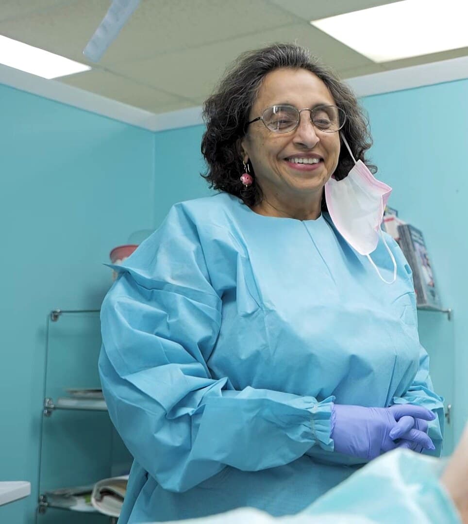Dr. Prabha Raju smiling with a patient in a treatment room at Tender Dental Care in Burton, Michigan